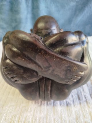 Escultura asiática de mármol, de Buda llorón.