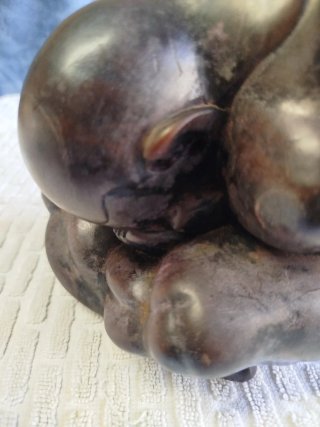 Escultura asiática de mármol, de Buda llorón.