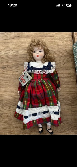 Muñeca de porcelana con vestido de cuadros