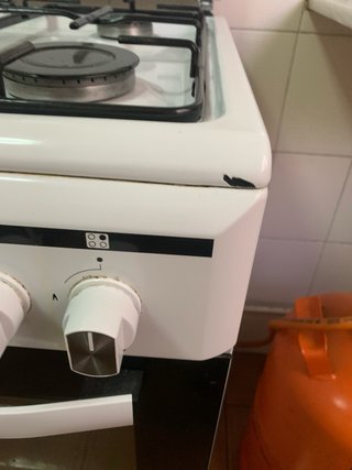 Cocina de gas butano blanca y negra con horno