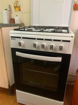 Cocina de gas butano blanca y negra con horno