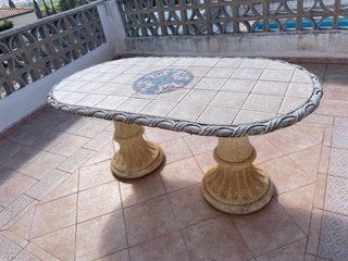 Mesa de piedra ovalada con azulejos