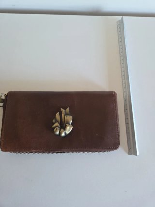 Cartera de mano cuero con adorno de latón.