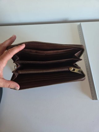 Cartera de mano cuero con adorno de latón.