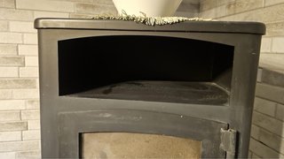 Estufa de leña negra con puerta de cristal