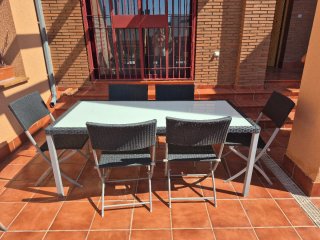 Mesa de jardín cristal y mimbre con 6 sillas.