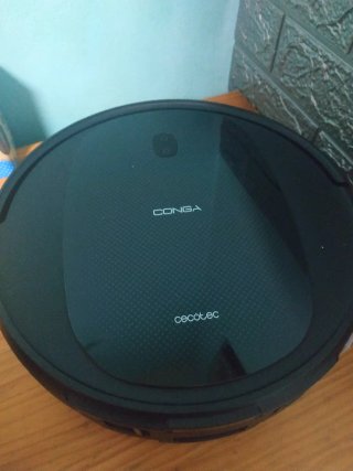 Robot aspirador negro con base de carga
