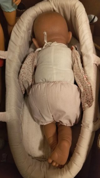 Muñeca bebé durmiendo en capazo