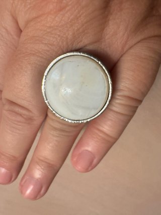 Anillo de metal plateado con piedra blanca