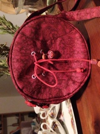 Bolso redondo fucsia con charm
