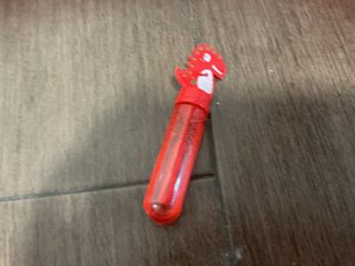 Bloque rojo, coche de juguete y pompero