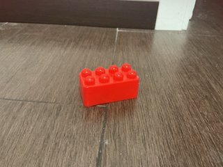 Bloque rojo, coche de juguete y pompero