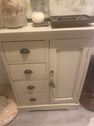 Armario auxiliar beige con puerta y cajones.