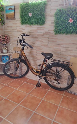 Bicicleta urbana dorada con cesta
