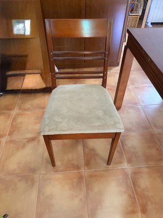 Mesa de comedor de madera con cuatro sillas.