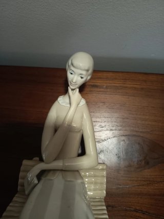 Joven pensativa sentada en un banco Descatalogada