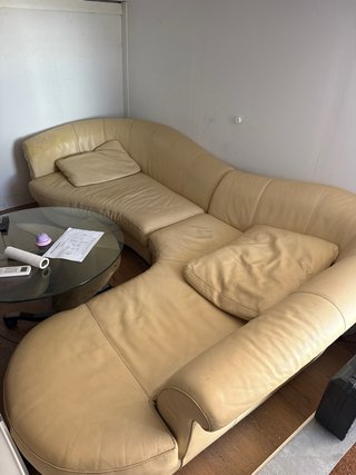 Sofá de piel beige curvo