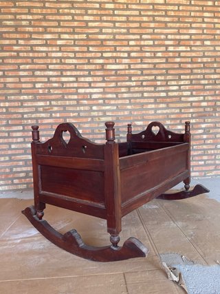 Cuna mecedora de madera barnizada