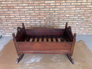 Cuna mecedora de madera barnizada