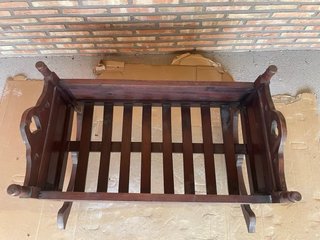 Cuna mecedora de madera barnizada