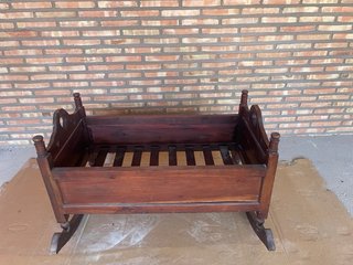 Cuna mecedora de madera barnizada