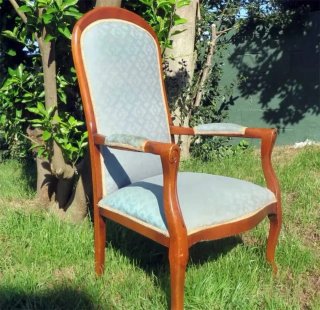 Butaca clásica de madera con respaldo alto.