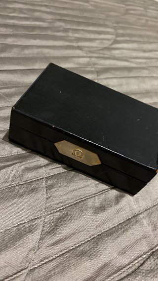 Caja de reloj Omega negra y dorada