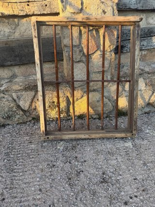 Reja antigua de forja con marco de madera