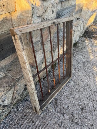 Reja antigua de forja con marco de madera