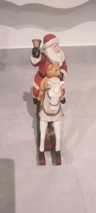 Papa Noel en balancín con oso y regalos