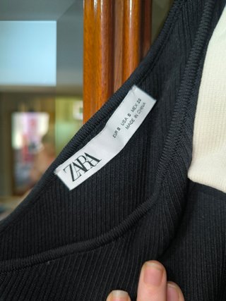 Top asimétrico de punto negro con lazo blanco de Z