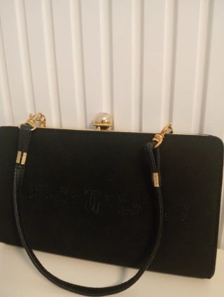 Bolso de mano negro de piel con detalles dorados