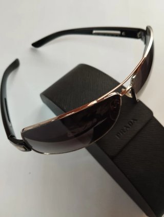 Gafas Prada negras y doradas con tara en lente izq