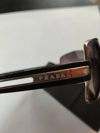 Gafas Prada negras y doradas con tara en lente izq