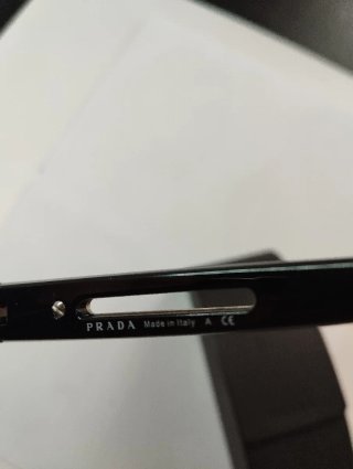 Gafas Prada negras y doradas con tara en lente izq