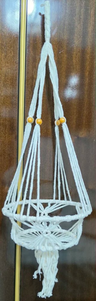 Colgador de macetas de macramé beige.