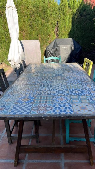 Mesa de jardín con azulejos y estructura de madera