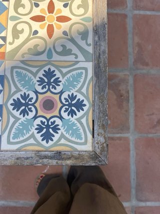 Mesa de jardín con azulejos y estructura de madera