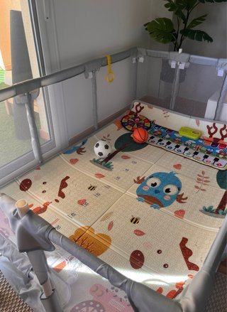 Parque infantil gris con accesorio