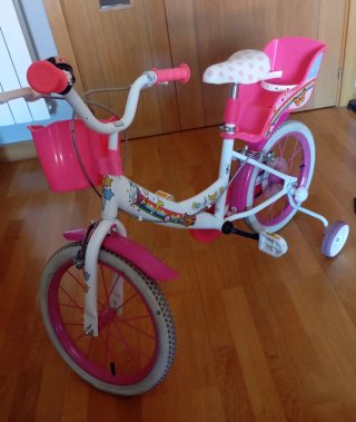 Bicicleta infantil rosa con cesta y ruedines