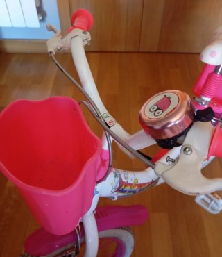 Bicicleta infantil rosa con cesta y ruedines