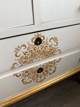 Cómoda blanca y dorada con detalles