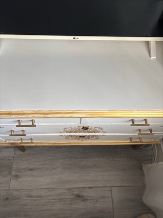 Cómoda blanca y dorada con detalles