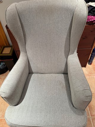 Sillon orejero tapizado en tela color gris.