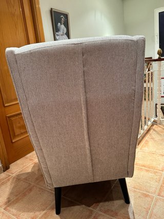 Sillon orejero tapizado en tela color gris.