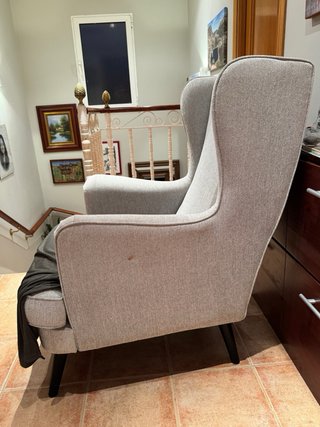 Sillon orejero tapizado en tela color gris.