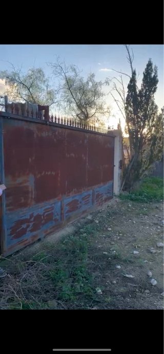Puerta de hierro con barrotes verticales