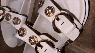Sandalias blancas con hebillas y adornos dorados