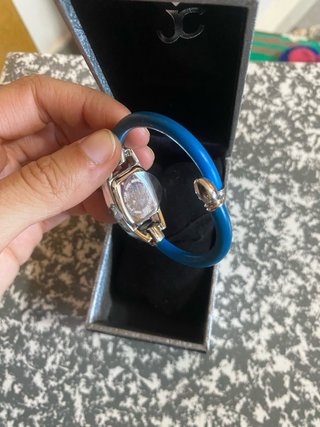 Reloj de pulsera plateado con pedrería azul