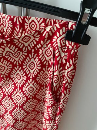 Pantalón fluido estampado rojo y beige.